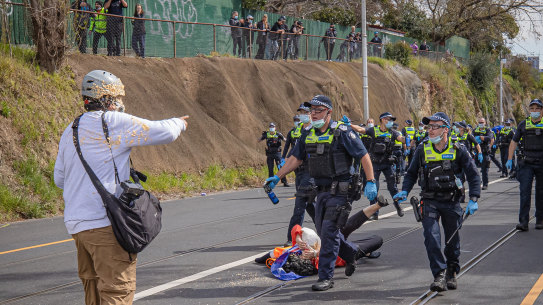 Age photographer Luis Ascui is pepper sprayed by a Victoria Police officer during the anti-lockdown protest in Richmond.