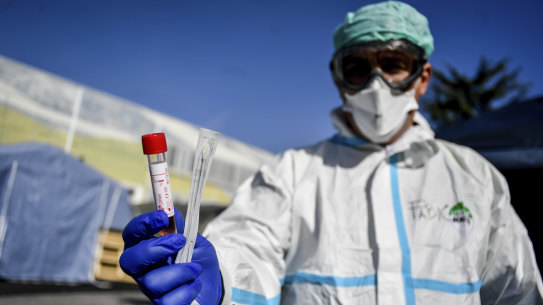 An Italian medico holds a coronavirus test kit outside a temporary medical facility set up to deal with coronavirus cases.