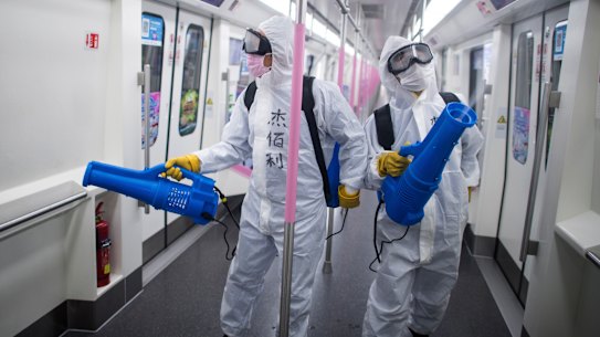 Workers disinfect a subway train in preparation for the restoration of public transport in Wuhan. 