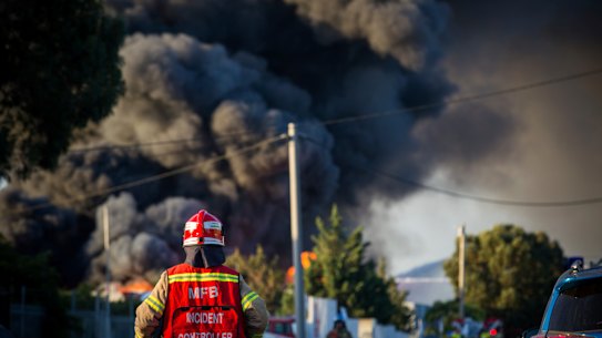 A MFB Incident Controller in front of the toxic smoke plumes.