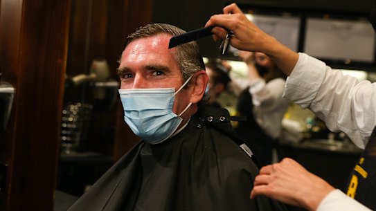 NSW Premier Dominic Perrottet receives a haircut in front of media at Barberhood in Sydney on Monday.