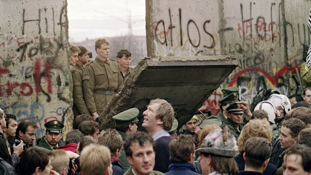 West Berliners watch East German border guards open up a new crossing point in the Berlin Wall in 1989.