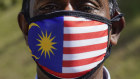 A supporter of Anwar Ibrahim's PKR wearing a national flag face mask as he gathers with others outside the National Palace in Kuala Lumpur, on , Wednesday.