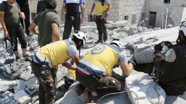 Syrian White Helmet workers search for victims in the rubble of a building hit by airstrikes in Deir al-Sharqi village, Idlib province, Syria, on Saturday.