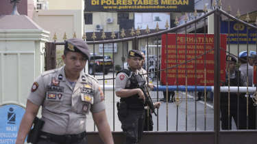 Police officers stand guard at the gate of the local police headquarters following a suicide bombing attack at the compound in Medan, North Sumatra, on Wednesday.
