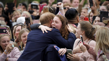 Prince Harry hugs India Brown outside Government House.