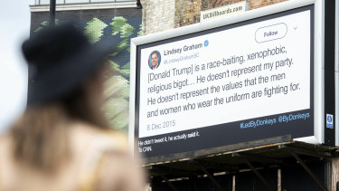 A woman views an anti-Donald Trump billboard displayed in London by the campaign group Led By Donkeys on Sunday.