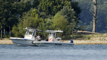 Emergency workers patrol an area near where the duck boat capsized.