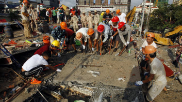 Rescuers try to remove rubble at the site of a collapsed seven-storey building in Cambodia.