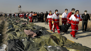 Rescue workers carry the body of a victim of the Ukrainian plane crash to a row of body bags, in Shahedshahr, south-west of Tehran, Iran, on Wednesday.