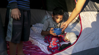Angel, 10, who broke his left leg playing soccer and is treated by Dr Dairon Elisondo Rojas in a migrant camp in Matamoros, Mexico.