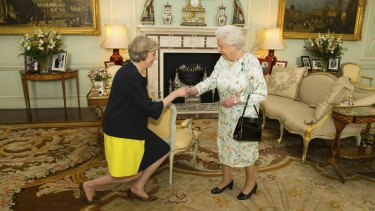Theresa May kneels before the Queen at Buckingham Palace, where the monarch invited May in 2016 to become Prime Minister and form a new government. 