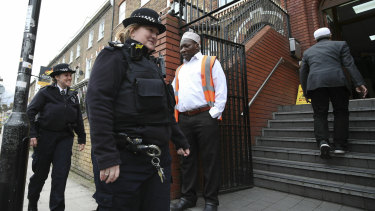 Police officers patrol the area outside Finsbury Park Mosque in London following the Christchurch mosque attacks, as worshipers begin to arrive for the Friday prayer service.