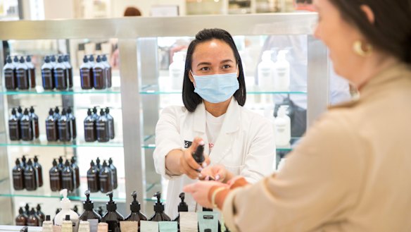 Testing times ... Okta Sampurna (left) helps a customer at the Grown Alchemist counter at David Jones in Melbourne, which has implemented several hygiene changes in its beauty department.