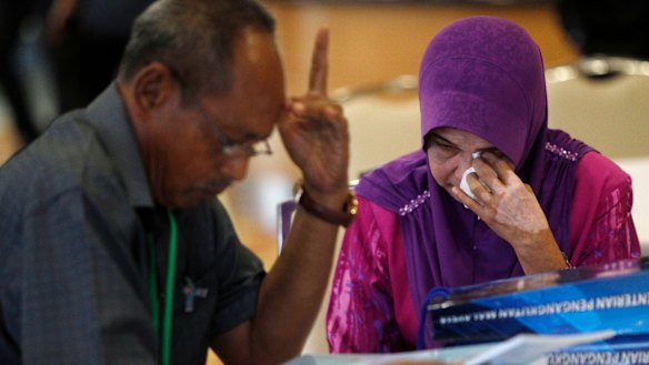 A relative of passengers on board the missing Malaysia Airlines Flight 370 reacts as she arrives for MH370 safety investigation report briefing at ministry of transportation in Putrajaya, Malaysia, Monday.