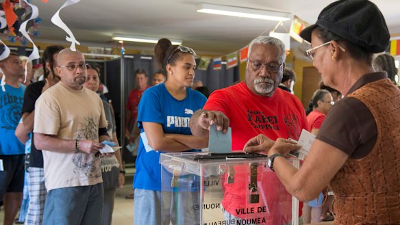 A man casts his vote at a polling station in Noumea, New Caledonia.