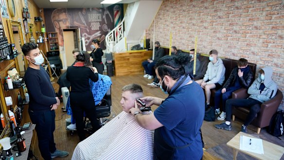 Customers have their hair cut at the Unique Traditional barber’s in Whitley Bay, England on Monday.