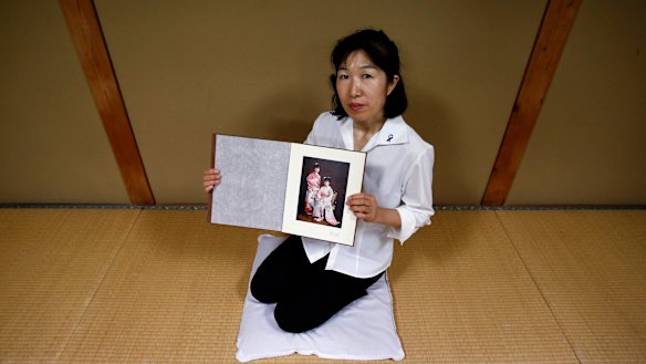 Misa Morimoto, identical younger twin of Miho Yamamoto, shows a photograph of Miho and herself on their 20th birthdays in 1984.