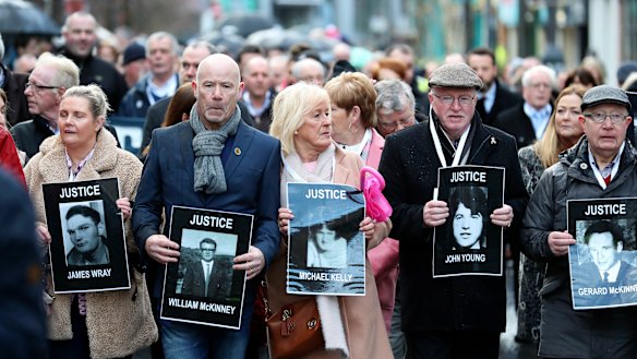 Families hold photographs of the victims of Bloody Sunday and march through the Bogside in Londonderry on Thursday.