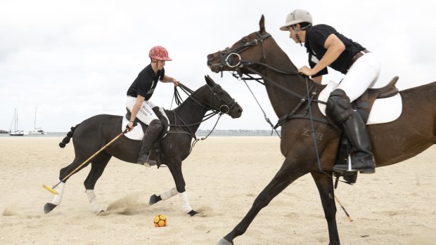 Professional polo players Blake Reid, left, riding Pop, and Josh Dales, riding Isla, enjoy a hit-out ahead of Twilight Beach Polo at St Kilda.
