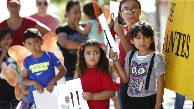 Children listen to speakers during an immigration family separation protest in Phoenix, Arizona, on Monday. 