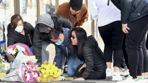 Thomas Tran's family in Eaton Mall where he died on Monday night. Mr Tran's mother Amy (right) sobs on the ground.