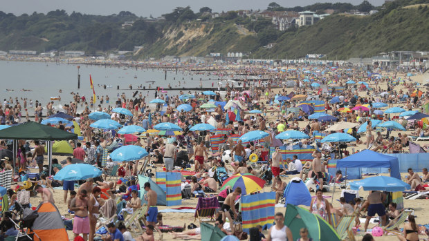 People relax on Bournemouth beach in Dorset , England, on Sunday as the hot weather continued across the country.