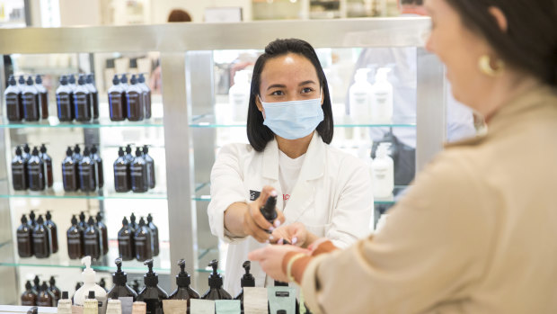 Testing times ... Okta Sampurna (left) helps a customer at the Grown Alchemist counter at David Jones in Melbourne, which has implemented several hygiene changes in its beauty department.