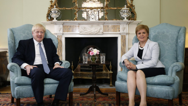 Scottish First Minister Nicola Sturgeon, right, sits with Boris Johnson.