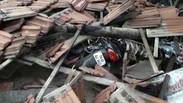 A motorcycle is covered in debris from a house that collapsed when a cyclone struck Nagapattinam, in the southern Indian state of Tamil Nadu, on Friday.