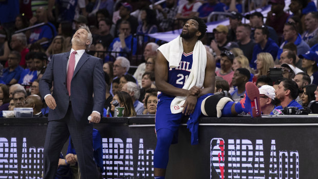 Philly coach Brett Brown and Joel Embiid look up at the scoreboard during the loss.