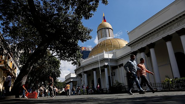 People walk outside the National Assembly in Caracas, Venezuela, which has two rivals claiming to be its president.