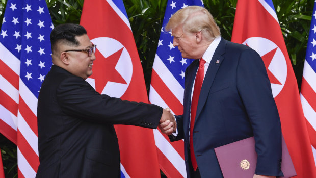 "In love": North Korea leader Kim Jong-un and US President Donald Trump shake hands at the conclusion of their meetings in Singapore in June. 