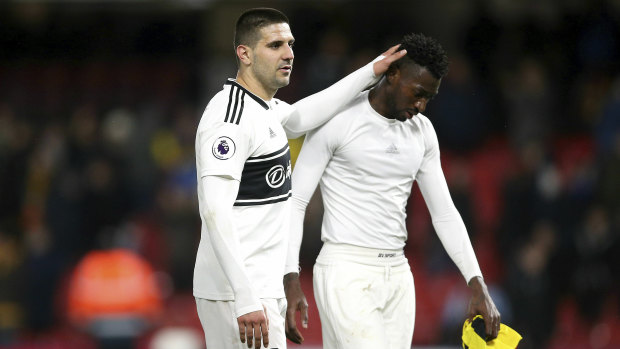 Despair: Fulham's Aleksandar Mitrovic consoles teammate Andre-Franck Zambo after the loss that confirmed the Cottagers' return to the Championship.