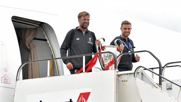 Manager Jurgen Klopp (left) and captain Jordan Henderson land in Liverpool with the trophy.