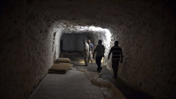 Fighters with the Free Syrian army walk in a cave where they live in order to be protected from bombing, in the outskirts of the northern town of Jisr al-Shughur, west of the city of Idlib, Syria. 