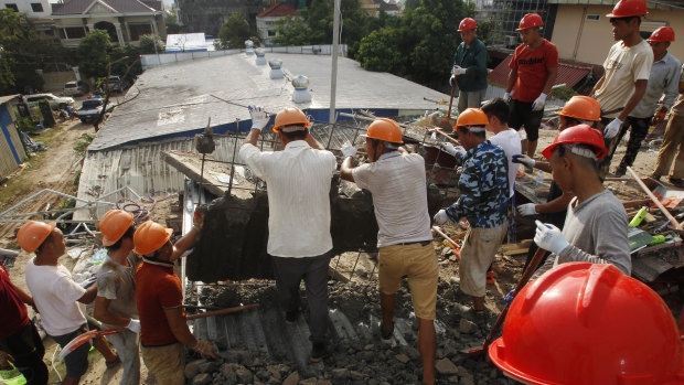 Rescuers try to remove the rubble at the site of a collapsed building in Preah Sihanouk province, Cambodia.