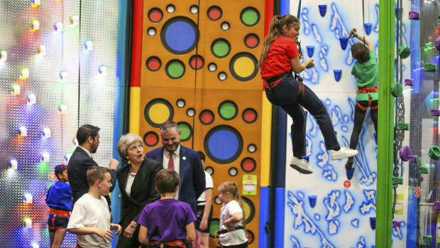 Britain's Prime Minister Theresa May looks on as Norr Fatima, aged 10, descends a climbing wall during a visit to Leisure Box, while on the local elections campaign in Brierfield, England.