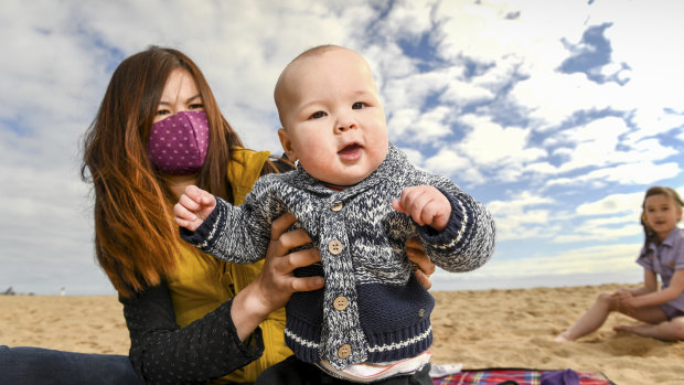 Mei Ling Tallis with her seven-month-old baby Charlie and eight-year-old daughter Kylie at Elwood Beach on Monday. 
