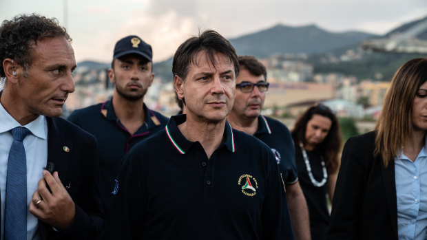 Giuseppe Conte, Italy's prime minister, centre, arrives at the site of the collapsed Morandi motorway bridge in Genoa.