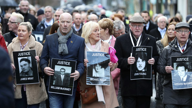 Families hold photographs of the victims of Bloody Sunday and march through the Bogside in Londonderry on Thursday.