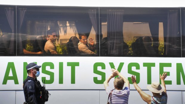 Supporters wave to refugees as they were removed by police from the Mantra hotel in Preston.