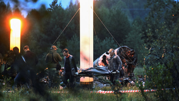 Emergency specialists carry a body bag near the wreckage of the private jet l<em></em>inked to Wagner mercenary chief Yevgeny Prigozhin.