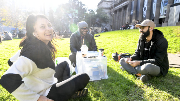 Carlton D’Silva (right), pictured having a coffee with friends Akshaya and Kenneth outside the State Library, said he had seen some people not abide by social distancing, but none within his smaller group of friends.