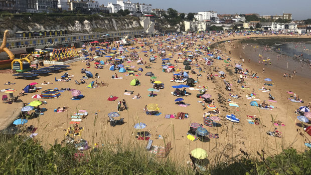 People flock to Broadstairs beach in Kent, England, on Thursday.