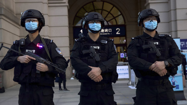 Police officers wearing face masks to protect against the spread of new coronavirus stand guard outside of Hankou train station ahead of the resumption of train services in Wuhan on Wednesday.