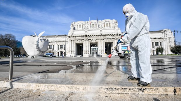 A worker wearing a protective suit disinfects the area in front of Milano Centrale, which is usually the bustling traffic centre of the country's business capital of Milan. 