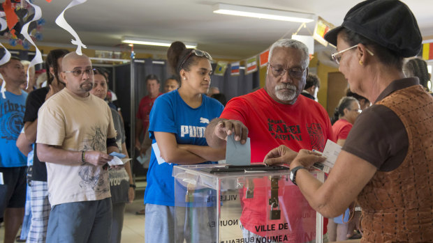A man casts his vote at a polling station in Noumea, New Caledonia.