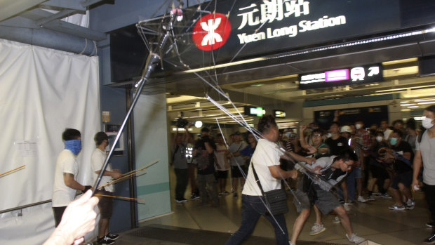 Men armed with metal rods and wooden poles attack commuters on Sunday.