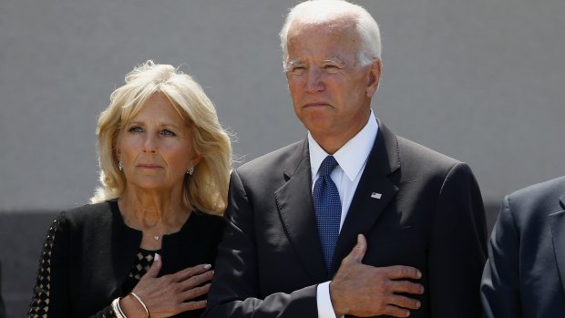 Former vice-president Joe Biden, right, and his wife Jill Biden, pause with hands over their hearts as they watch a military honour guard place the casket of Senator John McCain into a hearse.